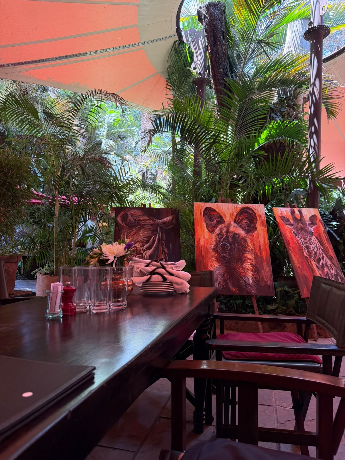 Paintings shown on easels beside a table in the Talisman garden