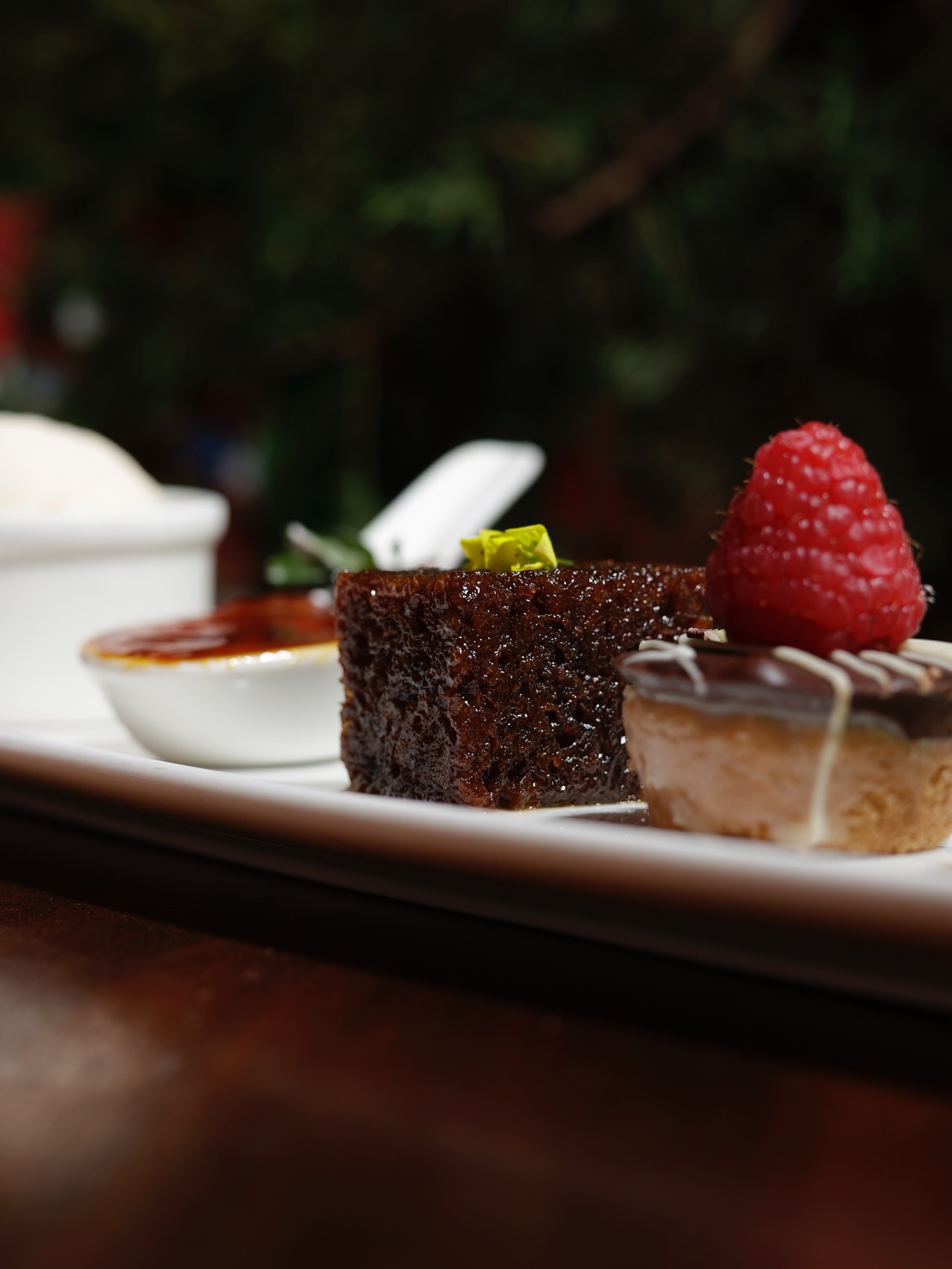 Sticky toffee pudding and chocolate tart on a long plate