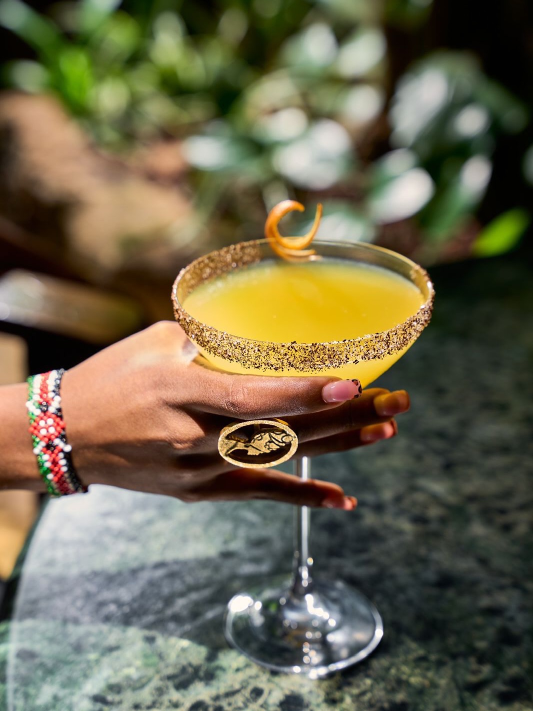 A gold-rimmed Dawa held against the greenery