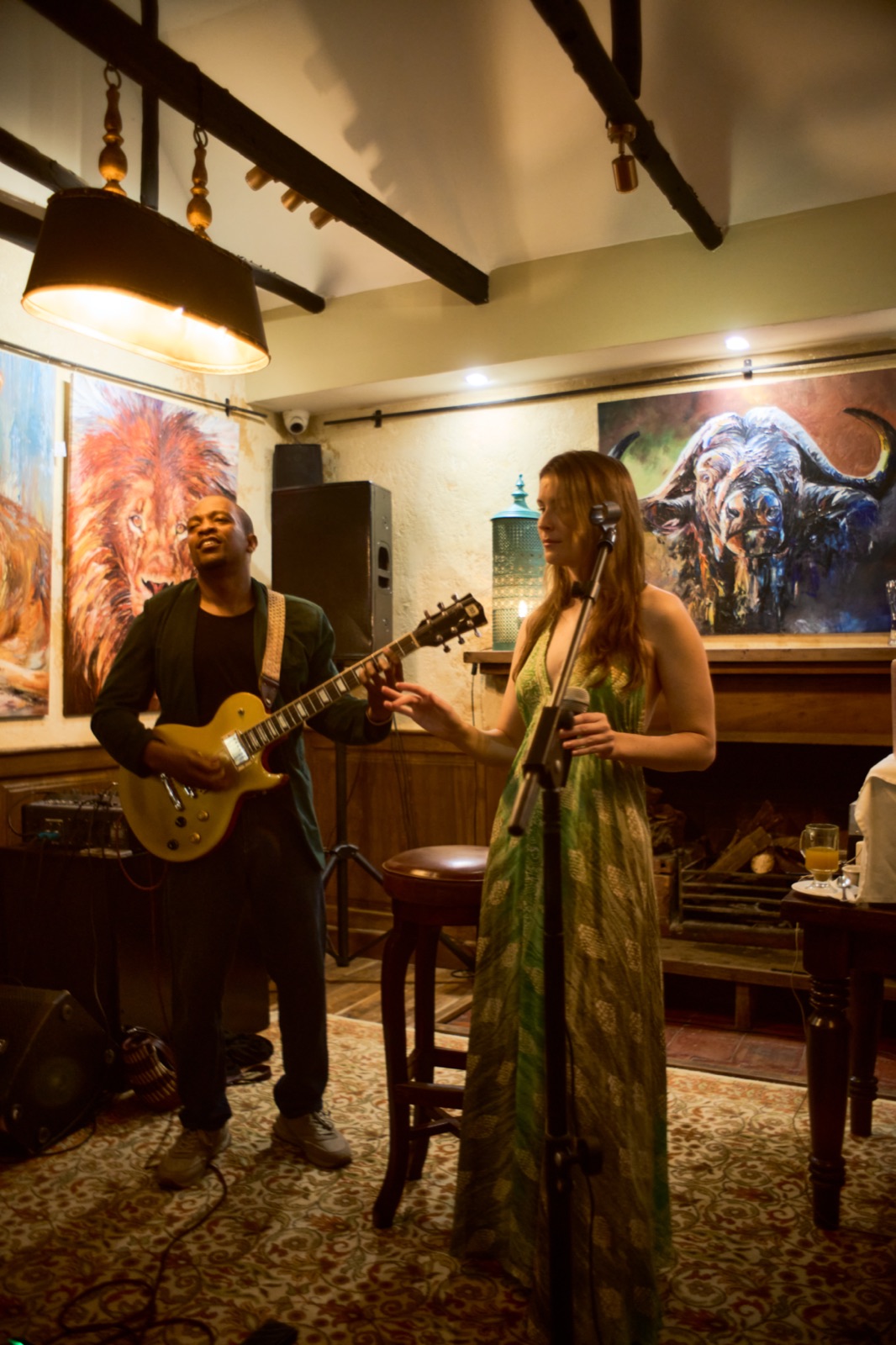 The guitarist playing beneath the wall art at Talisman